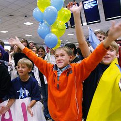 Andre Garrett, who was a Ukrainian orphan adopted by a family in Salt Lake City, waves to 45 orphans Thursday at airport.