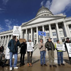 People hold signs during a press conference at the Capitol in Salt Lake City on Thursday, Jan. 14, 2016, urging support for the recolonization of Mexican gray wolves in southern Utah.


