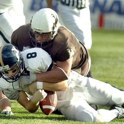 Wyoming's Zach Morris (55) tackles BYU's Matt Berry after a good gain just before the ball comes loose and Wyoming recovers and scores later on Oct. 18, 2003.