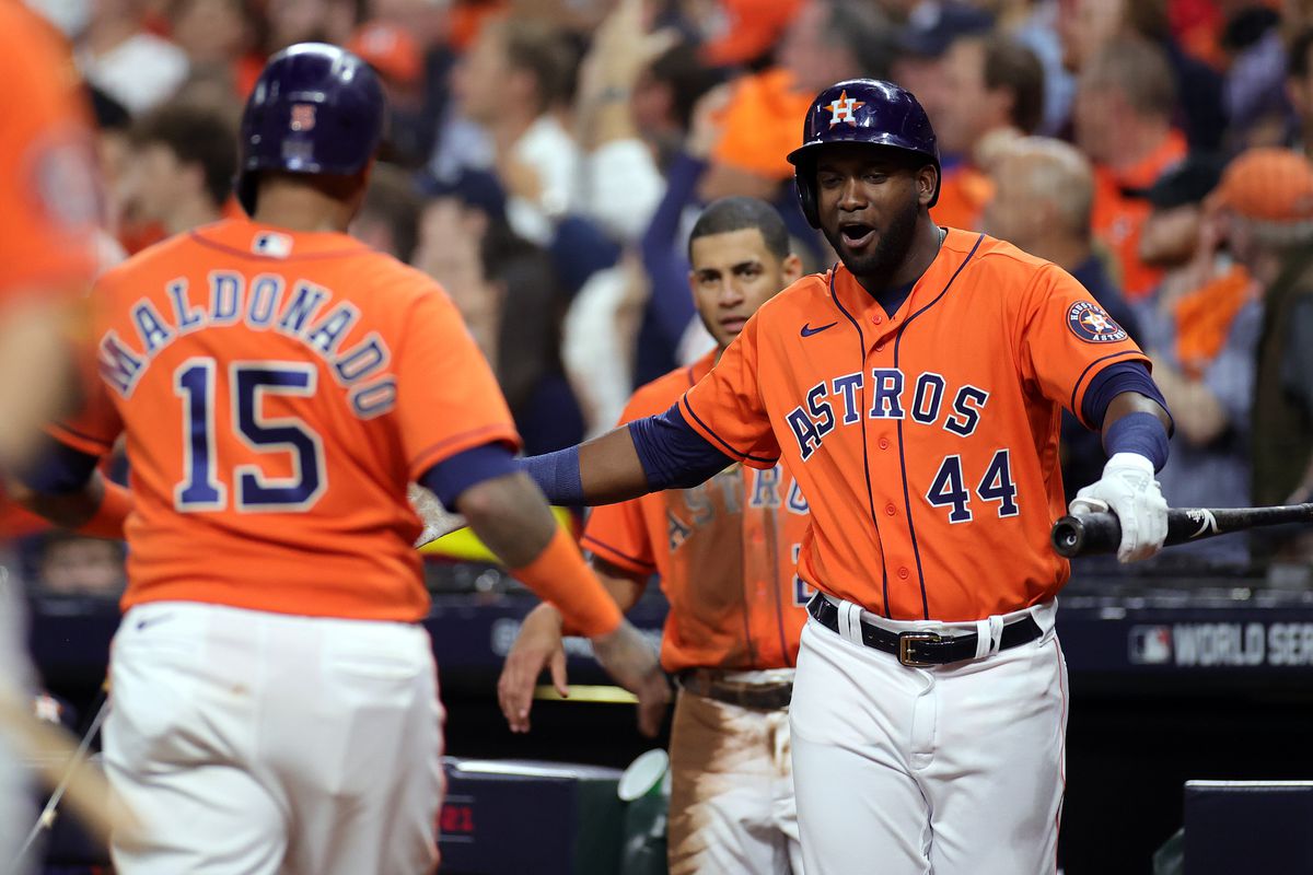 Martin Maldonado #15 of the Houston Astros is congratulated by Yordan Alvarez #44 after scoring a run against the Atlanta Braves during the second inning in Game Two of the World Series at Minute Maid Park on October 27, 2021 in Houston, Texas.