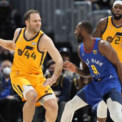 Utah Jazz forward Bojan Bogdanovic, left, looks to pass the ball as Denver Nuggets guard Davon Reed defends in the first half of an NBA basketball game Wednesday, Jan. 5, 2022, in Denver. 