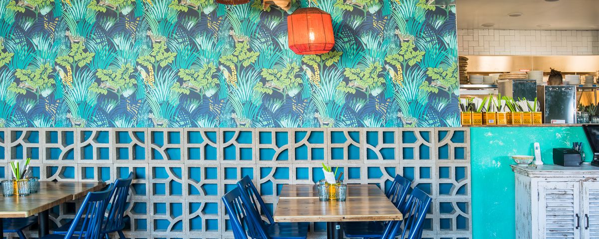 The brightly colored, wallpapered dining room at Hai Hai