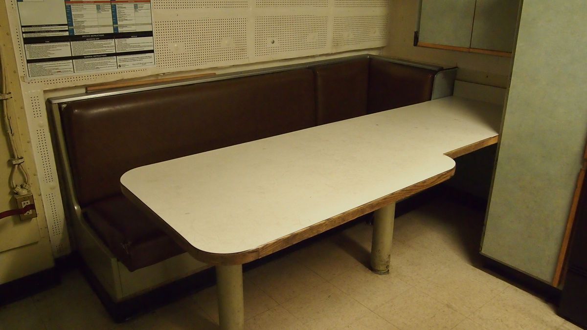 Brown bench seat with table in a break room