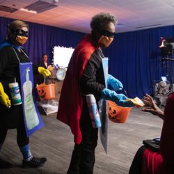 Mayor Lori Lightfoot and Dr. Allison Arwady, commissioner of the Chicago Department of Public Health, wear “Rona Destroyer” costumes and pass out candy to members of the media at City Hall before the start of a press conference about Halloween in Chicago, Thursday afternoon, Oct. 1, 2020.