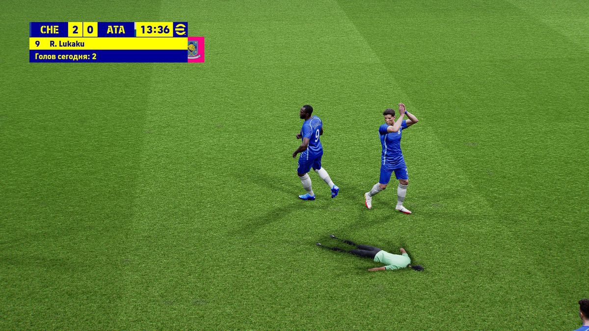 screenshot of a glitch in eFootball. The match official is face down, pressed into the pitch, while a Chelsea player applauds