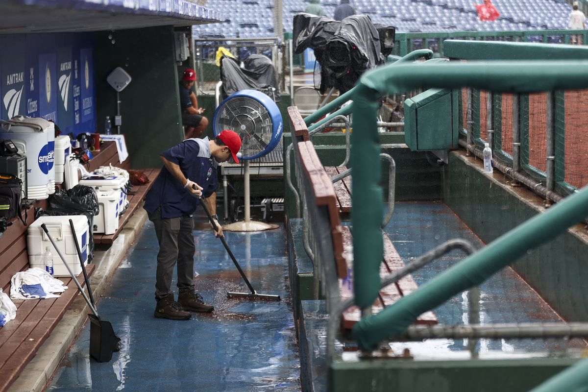 Rain is cleared from a dugout during a rain delayed game between the Washington Nationals and Philadelphia Phillies at Citizens Bank Park on September 11, 2022 in Philadelphia, Pennsylvania.