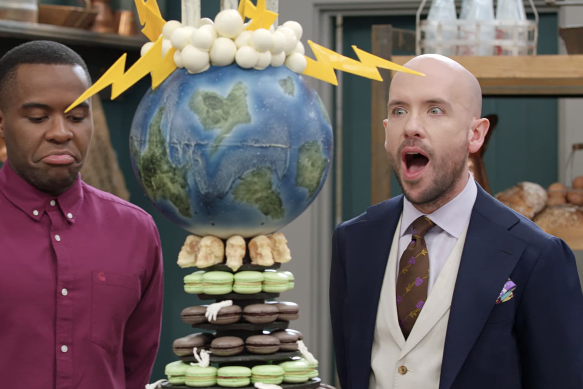 Tom Allen and Liam Charles reacting to a team’s showstopper challenge of a pastry shaped like the Earth.