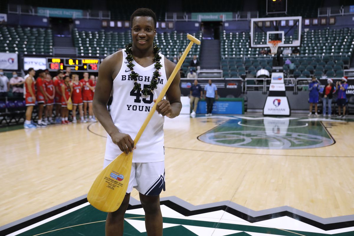 BYU forward Fousseyni Traore holds an All-Tournament Team trophy, a paddle