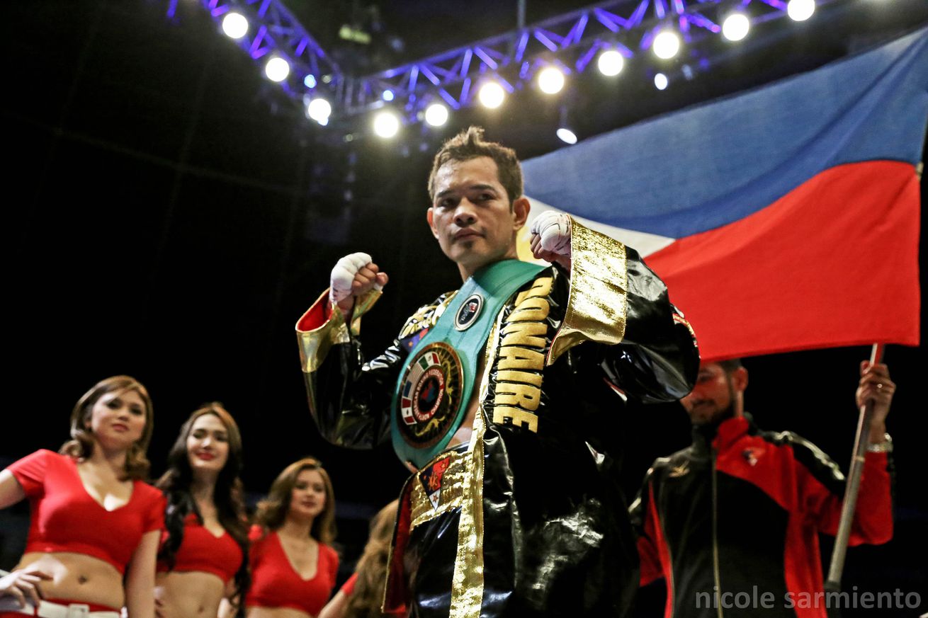 Nonito Donaire poses with his title belt, and the Philippine flag during a boxing event, Pinoy Pride 30