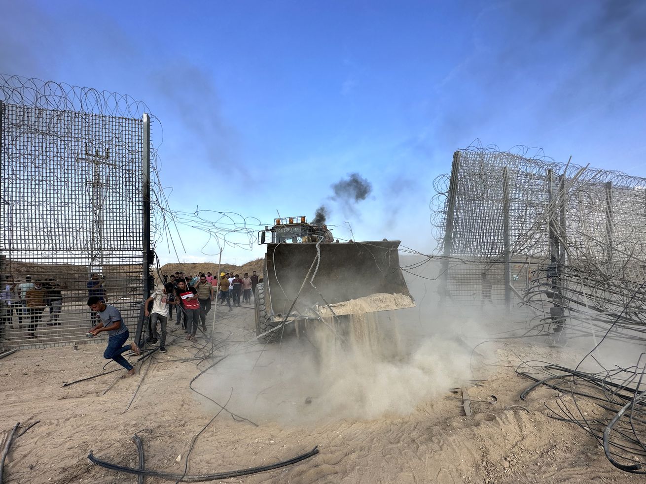 A truck is seen breaking through a fence. 