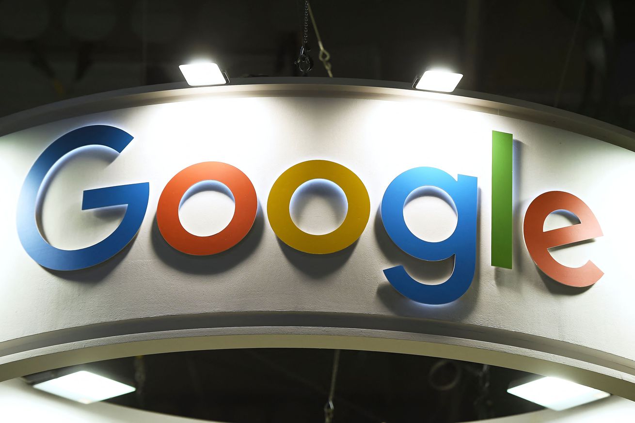 Google’s logo is seen above an entrance in a conference hall. 