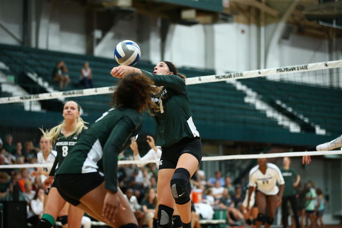 Michigan State volleyball player hits the ball during a match.