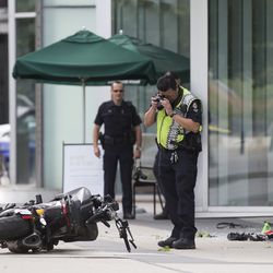 A police officer photographs a motorcycle after a female stunt driver working on the movie "Deadpool 2" died after a crash on set, in Vancouver, B.C., on Monday Aug. 14, 2017. Vancouver police say the driver was on a motorcycle when the crash occurred on the movie set on Monday morning.