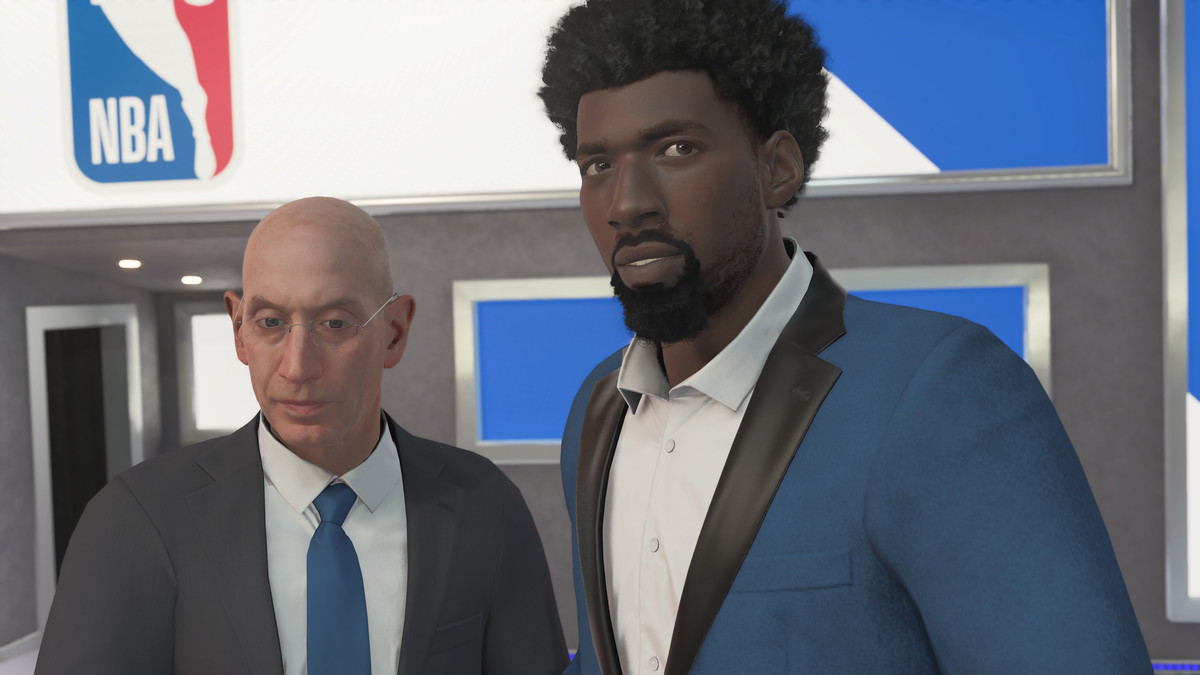 In a scene from NBA 2K23, the created player is shown on draft night, eyeing the crowd nervously as he is booed on the stage. NBA commissioner Adam Silver is beside him at left.