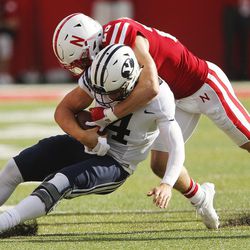 Brigham Young Cougars quarterback Taysom Hill (4) is tackled hard by Nebraska Cornhuskers safety Nate Gerry (25)  in Lincoln Saturday, Sept. 5, 2015. BYU won 33-28 on a last-second touchdown pass. 