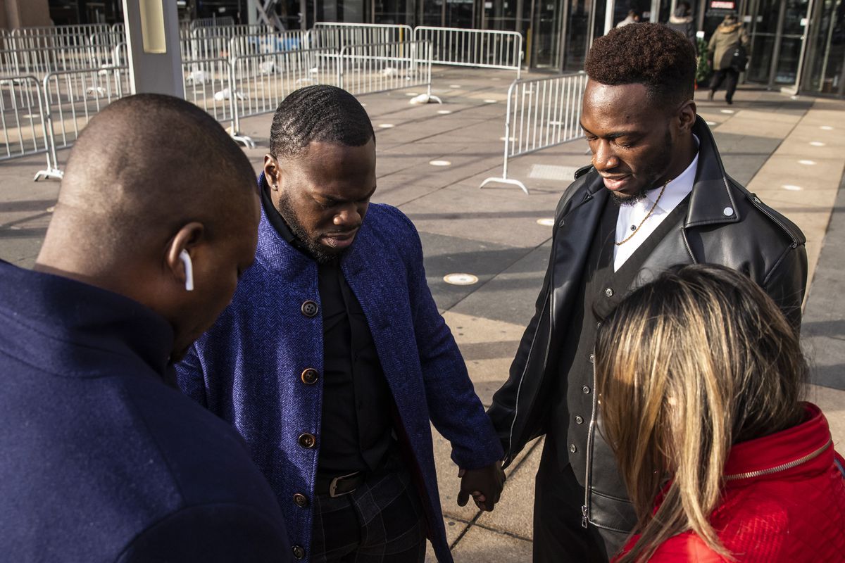 Olabinjo Osundairo (center left, in blue), Abimbola Osundairo (center right, in black) pray with their attorney and a supporter as they walk into the Leighton Criminal Courthouse for the Jussie Smollett trial on Thursday.