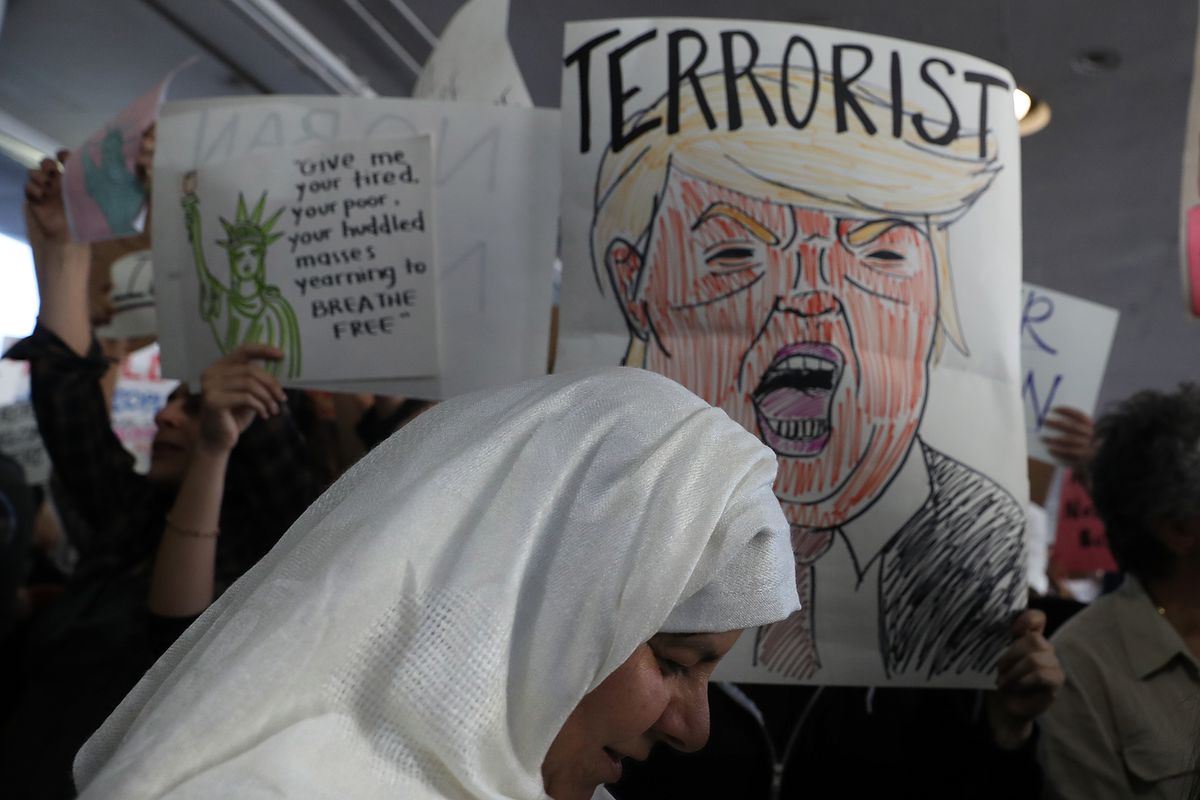 Protesters hold signs during a demonstration against the immigration ban that was imposed by U.S. President Donald Trump at Los Angeles International Airport on January 29, 2017 in Los Angeles, California.