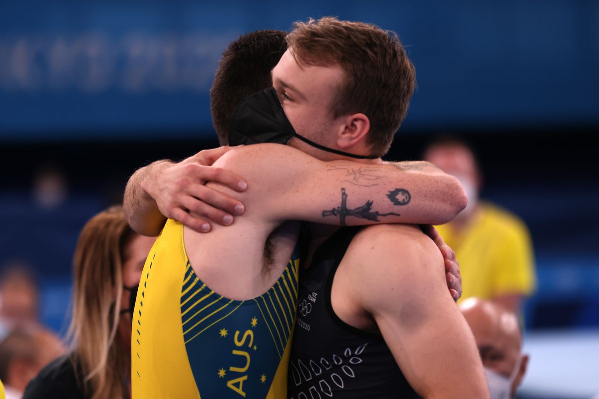 Dominic Clarke, left, hugs Dylan Schmidt of Team New Zealand after the trampoline finals.