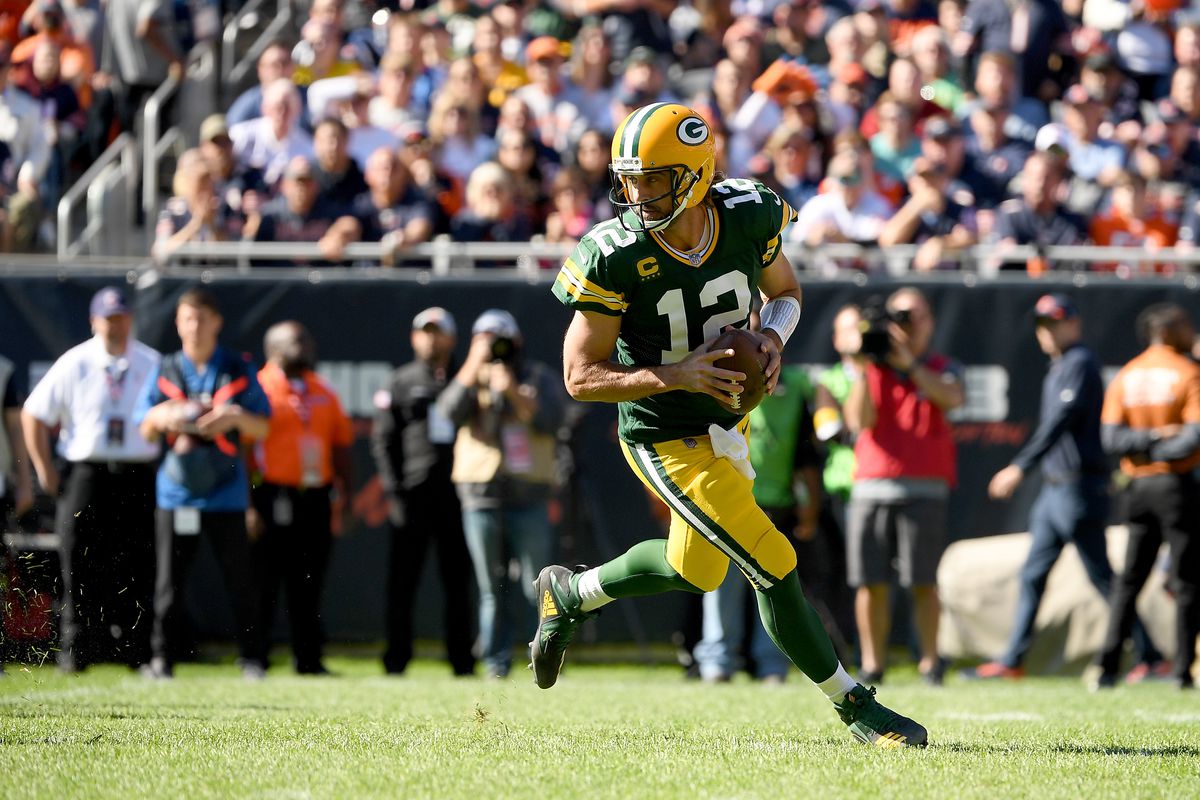 Aaron Rodgers #12 of the Green Bay Packers scrambles with the ball against the Chicago Bears in the first half at Soldier Field on October 17, 2021 in Chicago, Illinois.