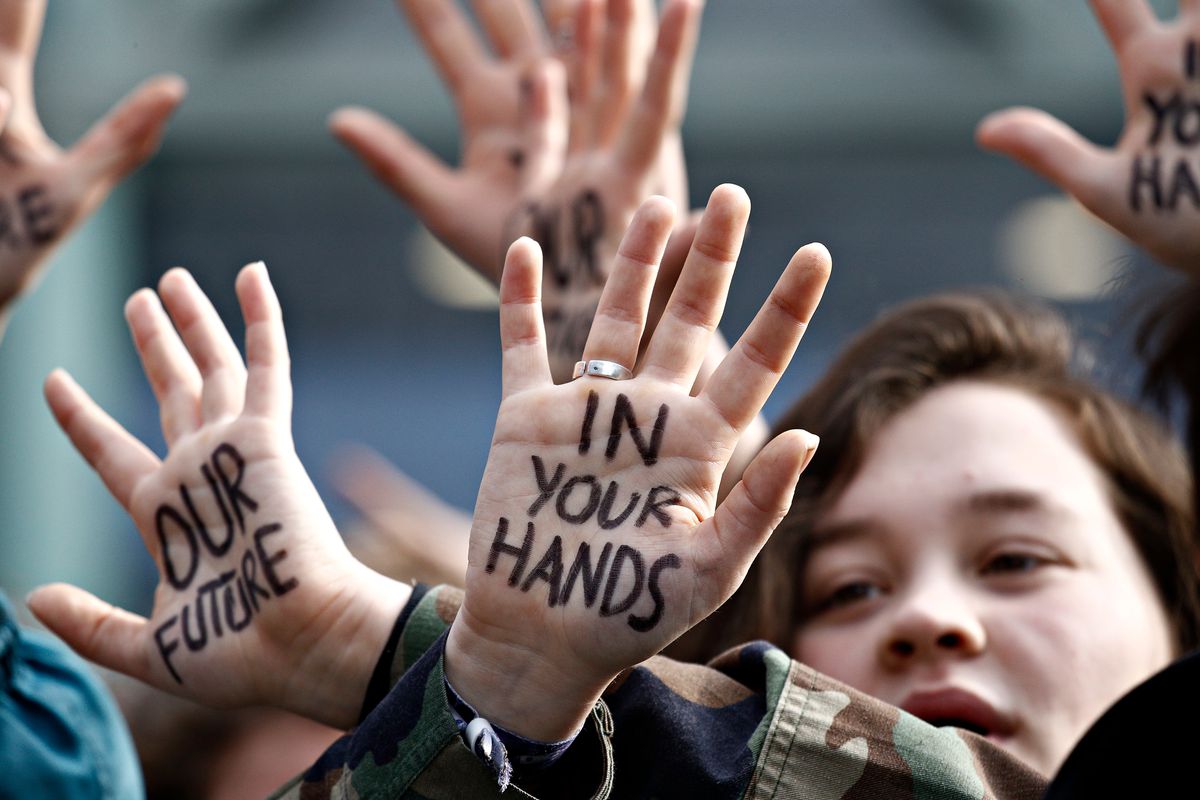 Protestor with “Our future in your hands” written on their hands. 