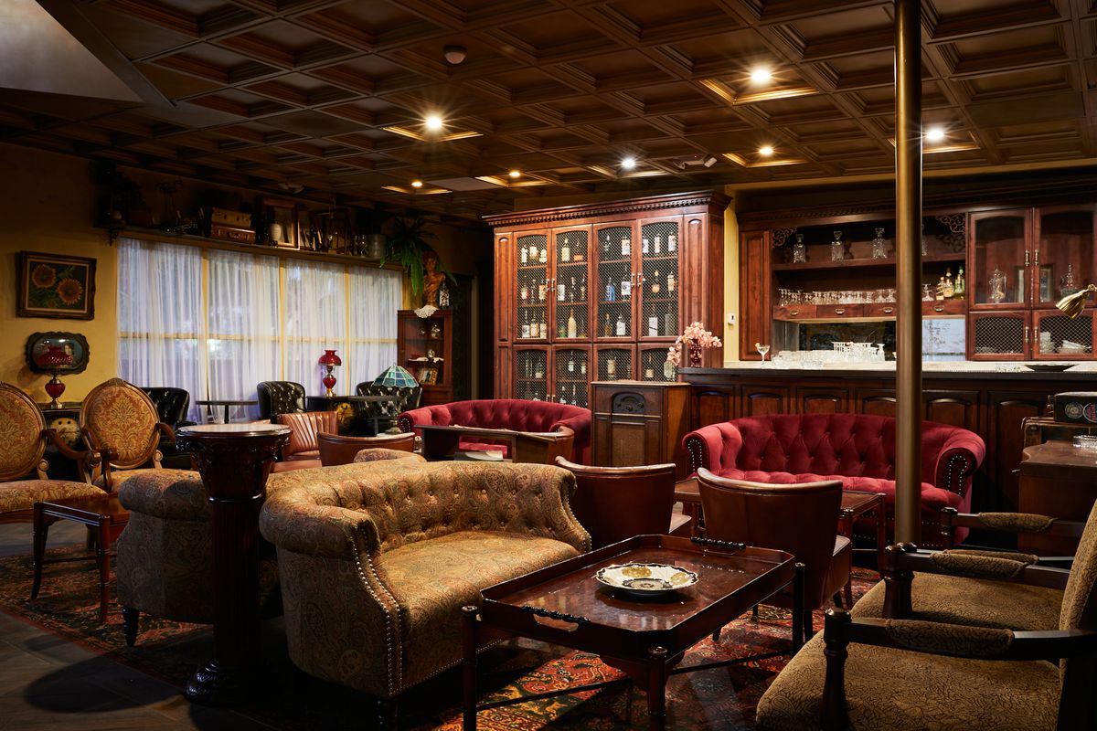 Couches and stools stuffed in a vintage room for drinking.
