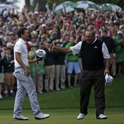 Angel Cabrera, of Argentina, gives Adam Scott, of Australia, a thumbs up after Scott made a birdie putt on the second playoff hole to win the Masters golf tournament Sunday, April 14, 2013, in Augusta, Ga. 