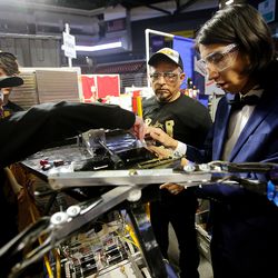 Rachel Arlen works on the robot with teacher Yuri Perez, and Mahammad Noori and others from Cottonwood High School as they compete in the First Robotics Competition Utah Regional event at the Maverik Center in West Valley City, Utah, on Friday, March 29, 2019.