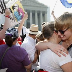 American University students Sharon Burk, left, and Molly Wagner, embrace outside the Supreme Court in Washington, Wednesday, June 26, 2013, after the court cleared the way for same-sex marriage in California by holding that defenders of California's gay marriage ban did not have the right to appeal lower court rulings striking down the ban.  