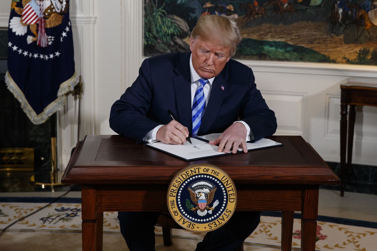 President Donald Trump signs a Presidential Memorandum on the Iran nuclear deal from the Diplomatic Reception Room of the White House, Tuesday, May 8, 2018, in Washington.
