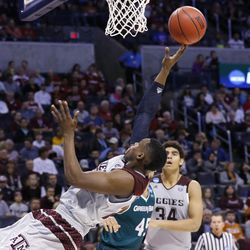 Texas A&M guard Danuel House, front, makes an off-balance shot in front of Green Bay forward Kenneth Lowe, center, and teammate Tyler Davis, in the second half of a first-round men's college basketball game in the NCAA Tournament, Friday, March 18, 2016, in Oklahoma City. (AP Photo/Alonzo Adams) 