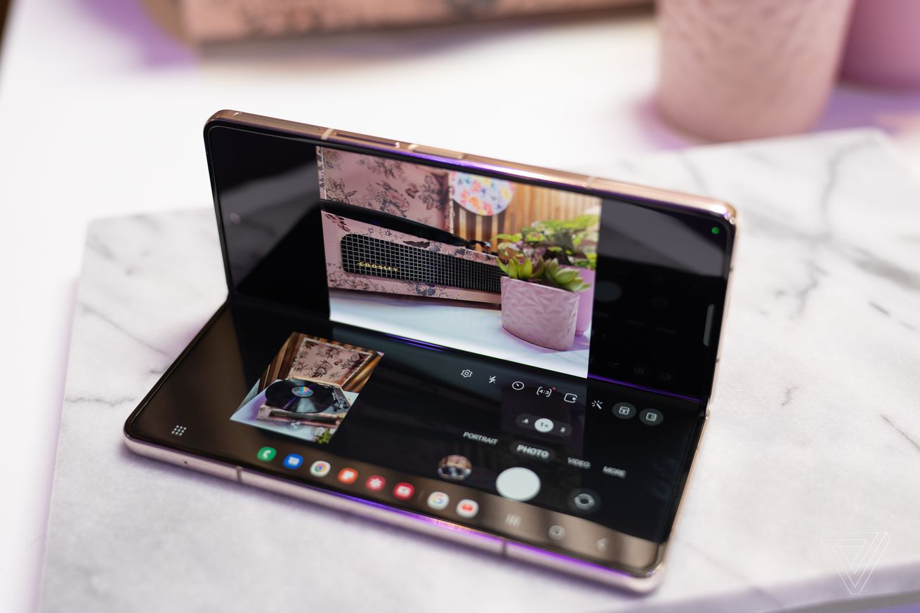 A photo of the Samsung Galaxy Z Fold 4, opened halfway, on a marble surface.