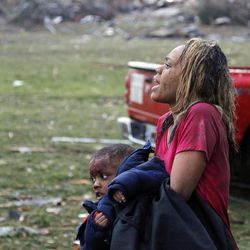 A woman carries an injured child to a triage center near the Plaza Towers Elementary School in Moore, Okla., Monday, May 20, 2013. A tornado as much as half a mile (.8 kilometers) wide with winds up to 200 mph (320 kph) roared through the Oklahoma City suburbs Monday, flattening entire neighborhoods, setting buildings on fire and landing a direct blow on an elementary school.