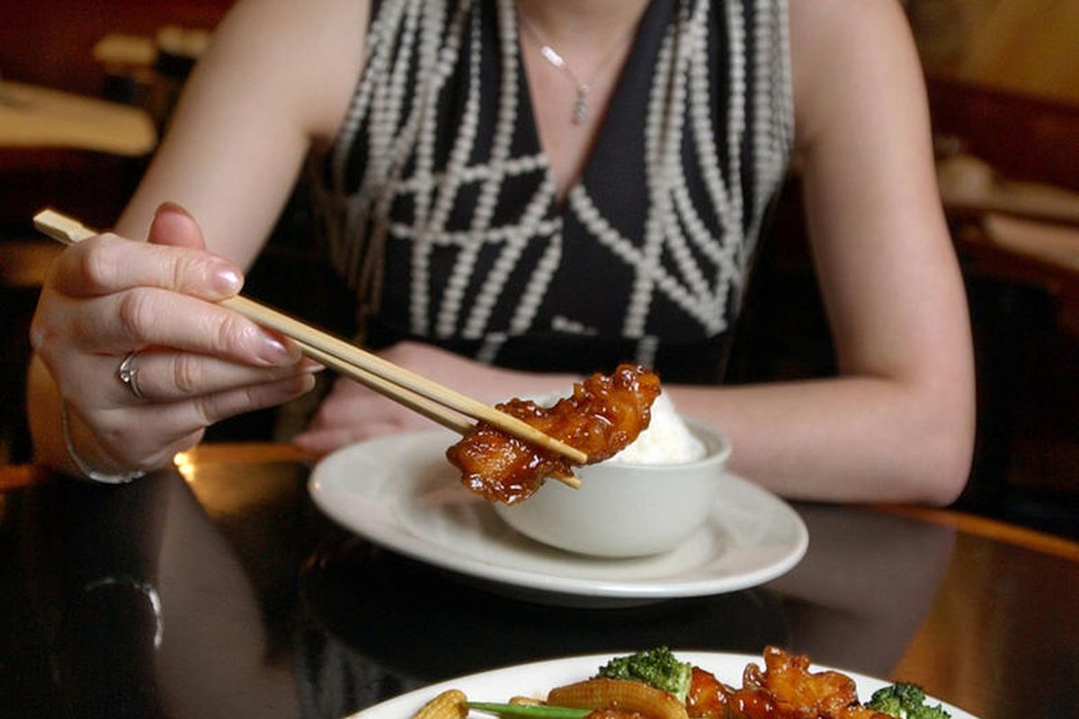 FILE— In this July 22, 2004 file photo, Tong Xian Mei, of Ollie's Restaurant, samples from a plate of General Tso's Chicken in New York. Chef Peng Chang-kuei, the chef who has been credited with inventing world-famous Chinese food staple that is not serve