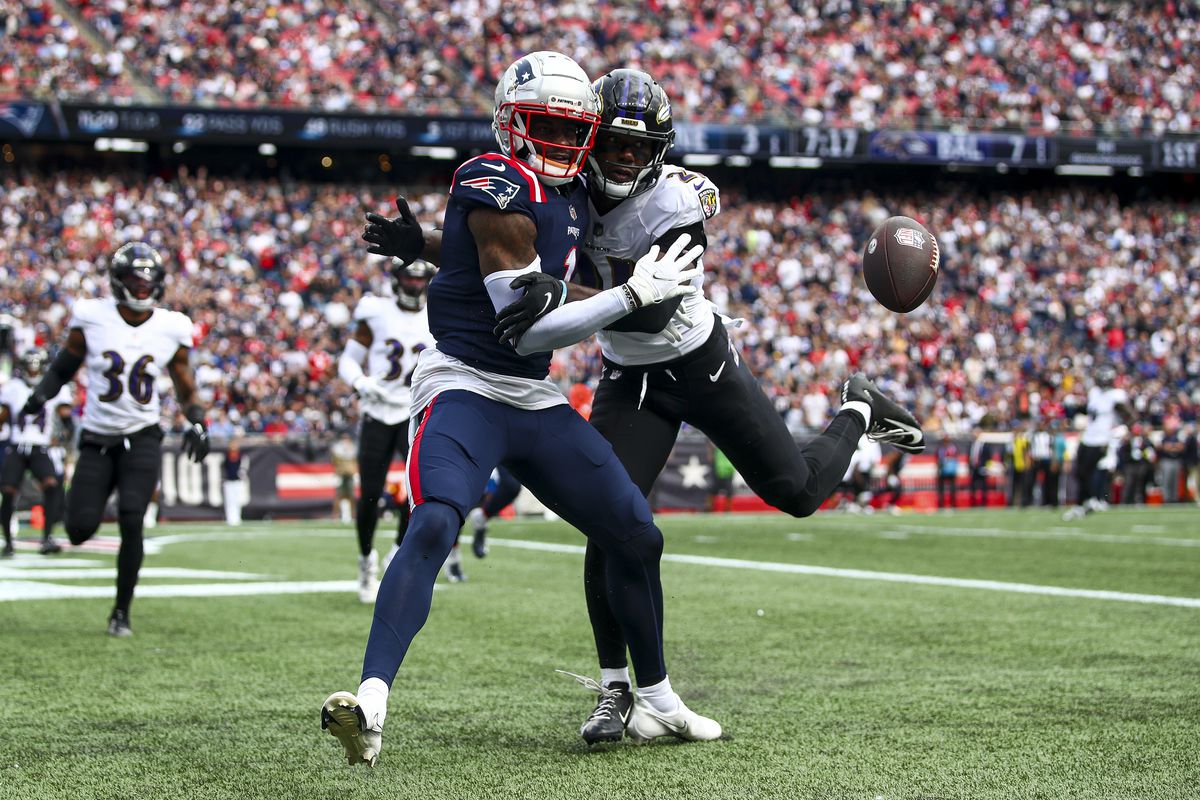 FOXBOROUGH, MASSACHUSETTS - SEPTEMBER 25: Cornerback Brandon Stephens #21 of the Baltimore Ravens knocks a defends a pass intended for wide receiver DeVante Parker #1 of the New England Patriots during the second half at Gillette Stadium on September 25, 2022 in Foxborough, Massachusetts.
