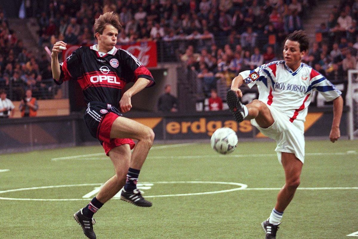 Didi Hamann and Jens Dowe leap acrobatically in the air, a contested ball between them, from an old match between Bayern and Hansa Rostock.