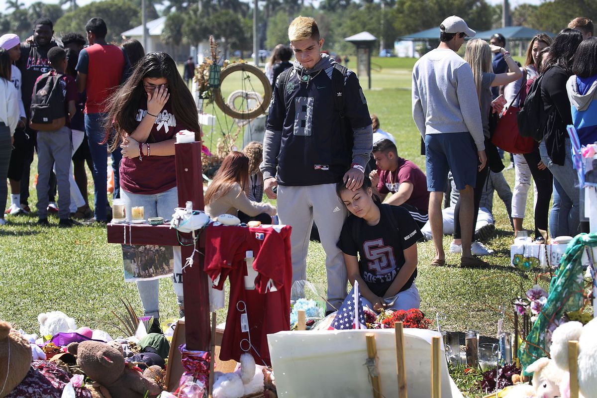 Students from Marjory Stoneman Douglas High School stand together at a memorial in March 2018 in Parkland, Florida.