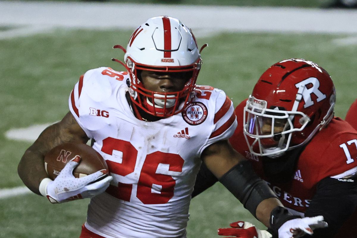 Dedrick Mills #26 of the Nebraska Cornhuskers rushes for yards against Deion Jennings #17 of the Rutgers Scarlet Knights during the fourth quarter at SHI Stadium on December 18, 2020 in Piscataway, New Jersey. Nebraska defeated Rutgers 28-21.