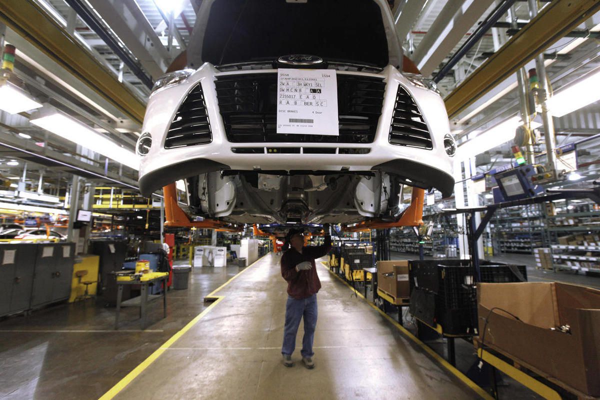 In this Dec. 14, 2011, file photo, a line worker assembles a 2012 Ford Focus at the Ford Michigan Assembly plant in Wayne, Mich. 