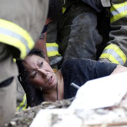 A woman is pulled out from under tornado debris at the Plaza Towers School in Moore, Okla., Monday, May 20, 2013. A tornado as much as half a mile (.8 kilometers) wide with winds up to 200 mph (320 kph) roared through the Oklahoma City suburbs Monday, flattening entire neighborhoods, setting buildings on fire and landing a direct blow on an elementary school. 