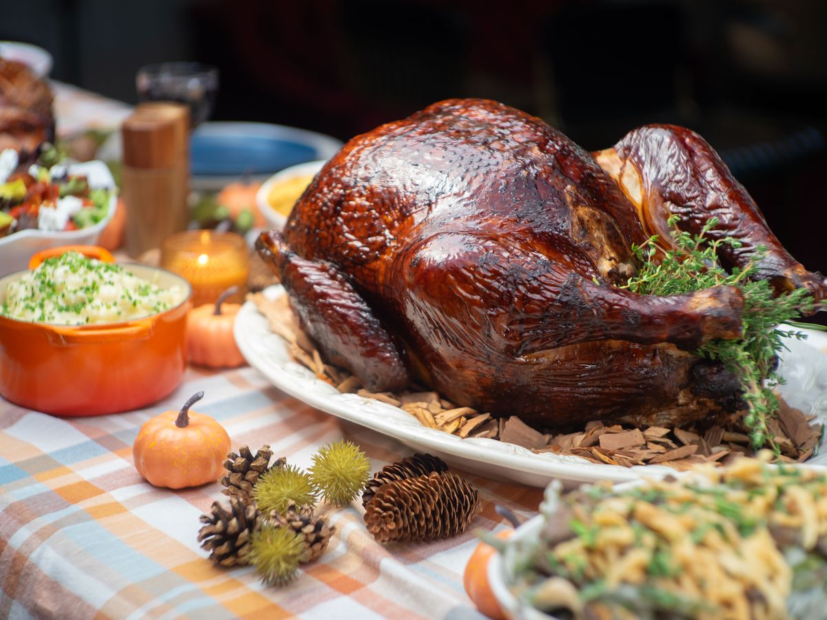 A large smoked turkey on a Thanksgiving table.