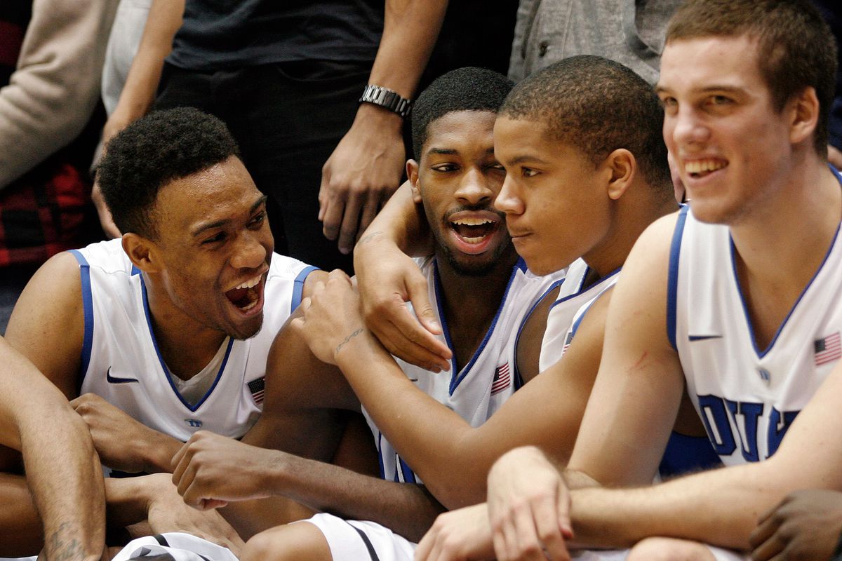 Duke Blue Devils forward Jabari Parker (1) and forward Amile Jefferson (21) and guard Andre Dawkins (34) celebrate on the bench at the end of their game against the Virginia Cavaliers at Cameron Indoor Stadium.