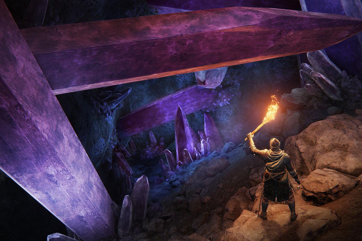 Elden Ring player holds up a torch in a crystalline cave