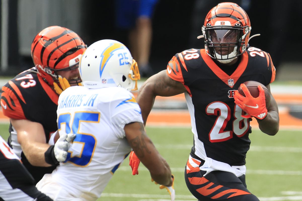 Running back Joe Mixon of the Cincinnati Bengals rushes in front of cornerback Chris Harris of the Los Angeles Chargers during the first half at Paul Brown Stadium on September 13, 2020 in Cincinnati, Ohio.