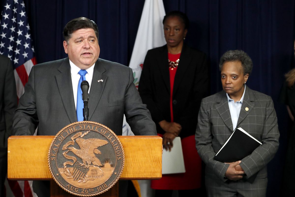 Gov. J.B. Pritzker announces a shelter-in-place order to combat the spread of the COVID-19 virus on Friday, as Mayor Lori Lightfoot looks on.