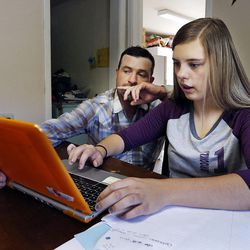 Riley Anderson helps his daughter Kaylee Delano, right, with homework in Orderville, Kane County, Thursday, Aug. 20, 2015.