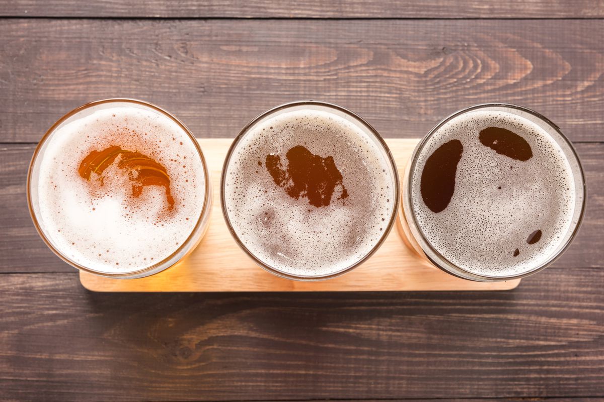 An aerial photograph of three glasses of beer, which increase in darkness from left to right