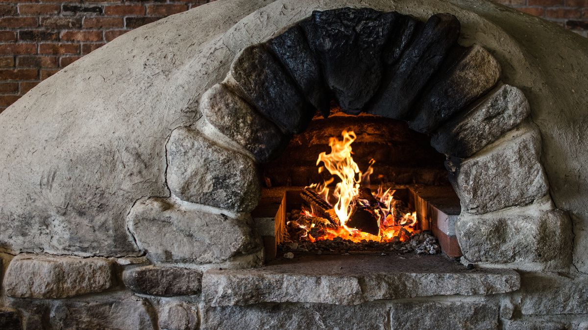 Closeup of a stone pizza oven with a fire going