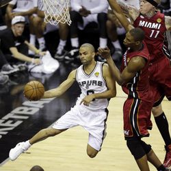 San Antonio Spurs point guard Tony Parker (9) passes the ball around Miami Heat forward Chris Andersen and center Chris Bosh (1) during the first half at Game 3 of the NBA Finals basketball series, Tuesday, June 11, 2013, in San Antonio. 