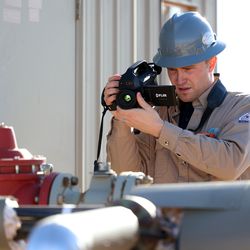 Stephen Foulger, an environmental scientist with the Utah Department of Environmental Quality, uses a Flir gas detection camera during an inspection of an oil pump site near Roosevelt on Wednesday, Dec. 1, 2021.