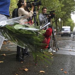 A man holding flowers waits before Spanish embassy staff members observed a minute of silence in memory of the terrorist attacks victims in Spain, Friday Aug.18, 2017 in the courtyard of the embassy in Paris. Spanish police say death toll in Spain attacks rises to 14 after woman injured in seaside resort dies.